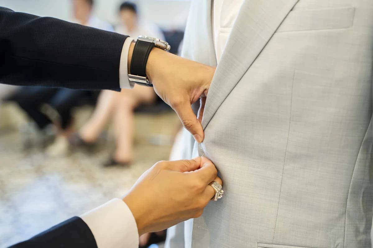 Cận cảnh tay thợ chỉnh sửa áo vest xám