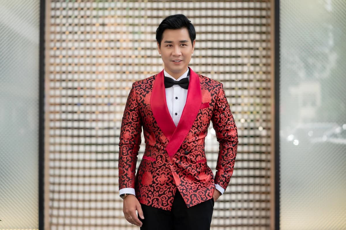 Nghệ sĩ mặc áo tuxedo hoạ tiết đỏ cổ shawl, nơ đen