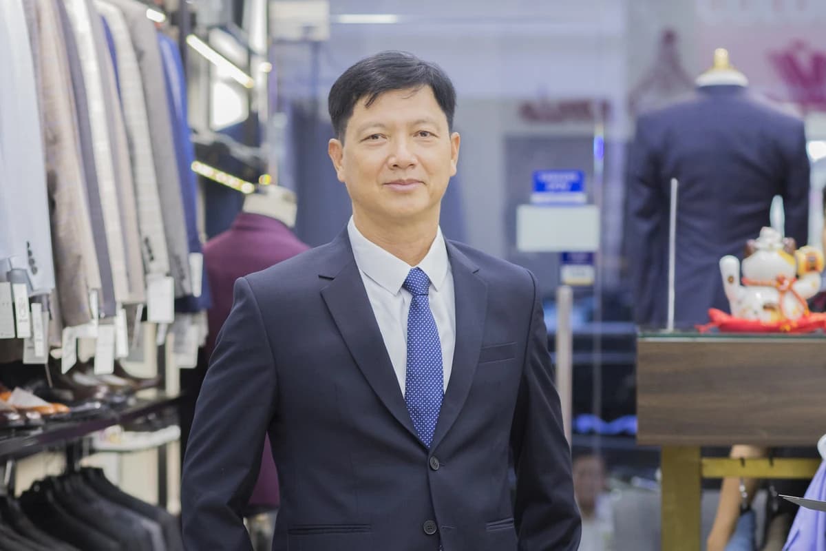 Quý ông mặc vest xanh navy, cà vạt xanh tại showroom