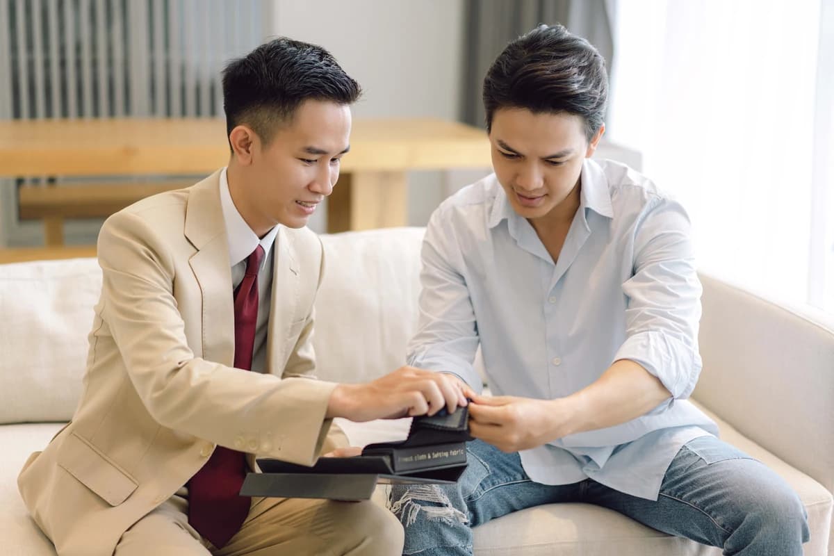 Thợ may mời khách xem mẫu vải ngay tại nhà