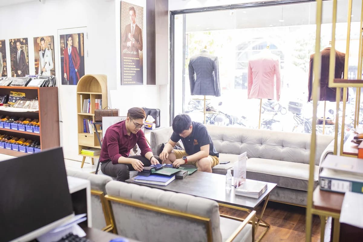 Nhân viên và khách xem mẫu vải tại bàn sofa showroom