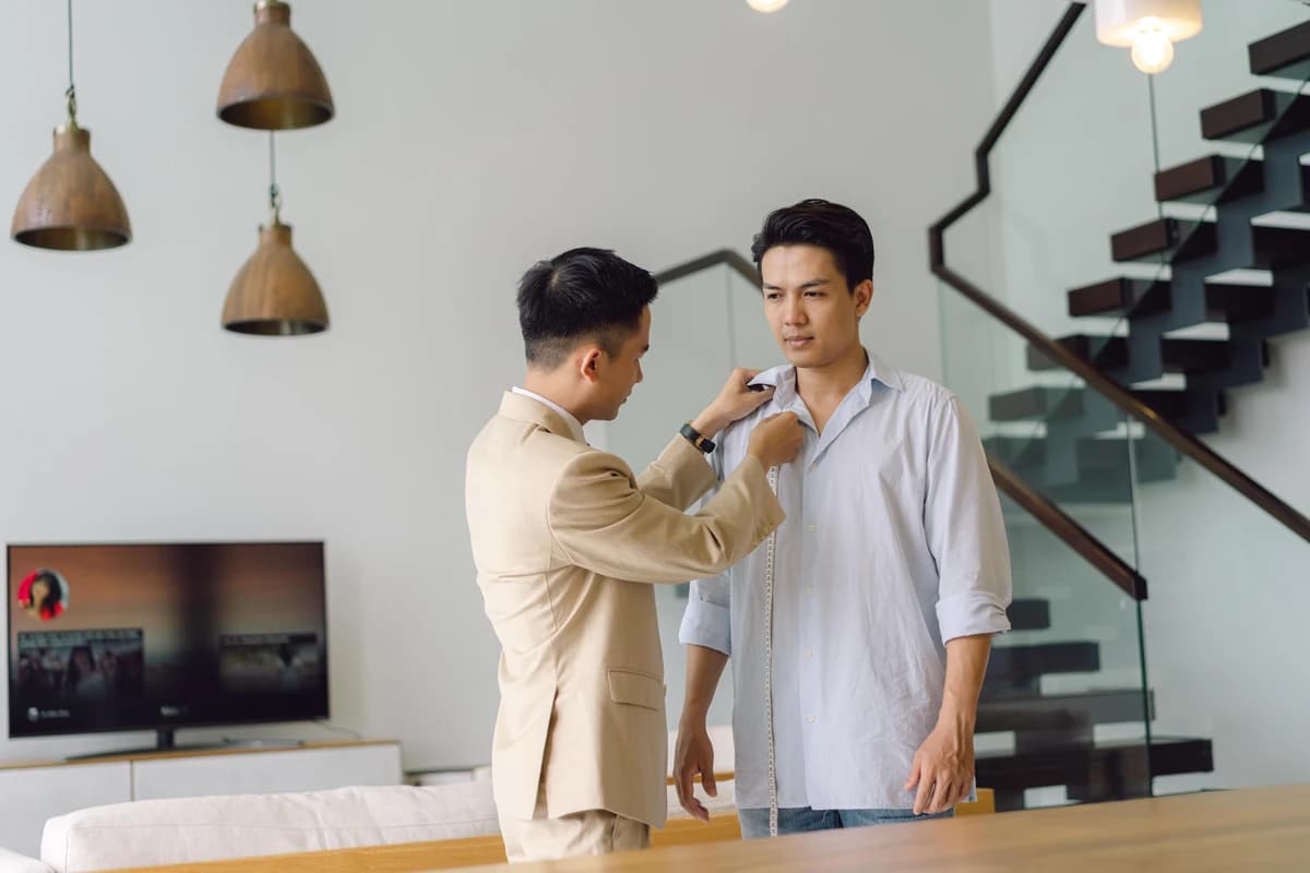 Thợ may đo cổ và vai cho khách bên cầu thang