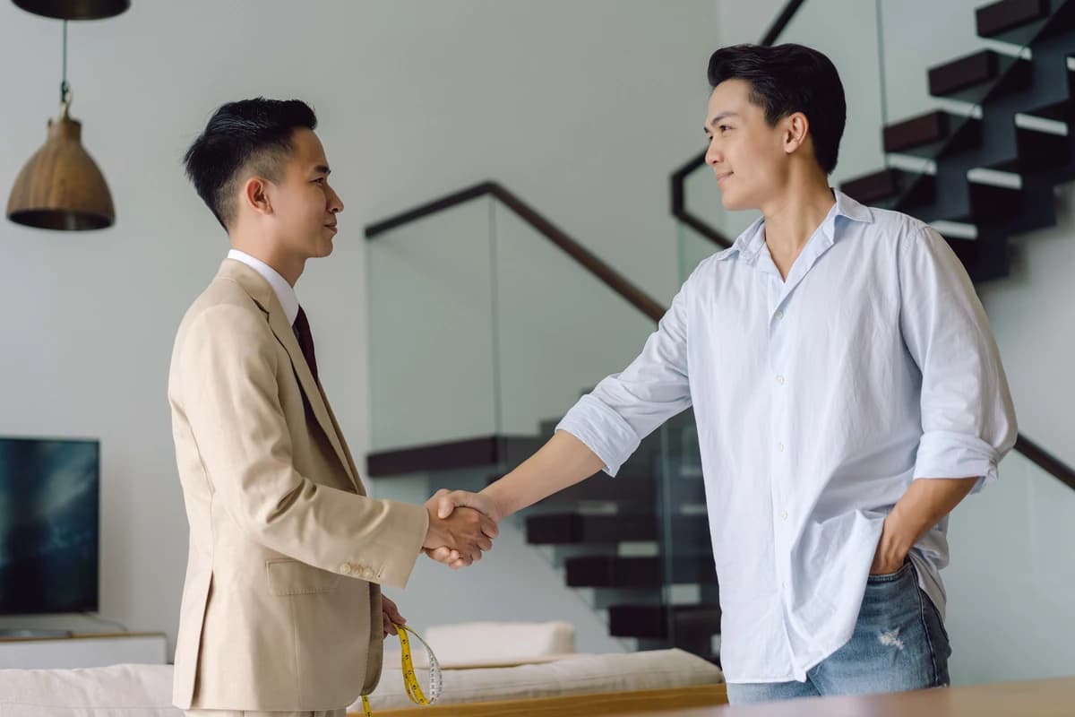 Khách và thợ may bắt tay hoàn tất dịch vụ trong căn hộ