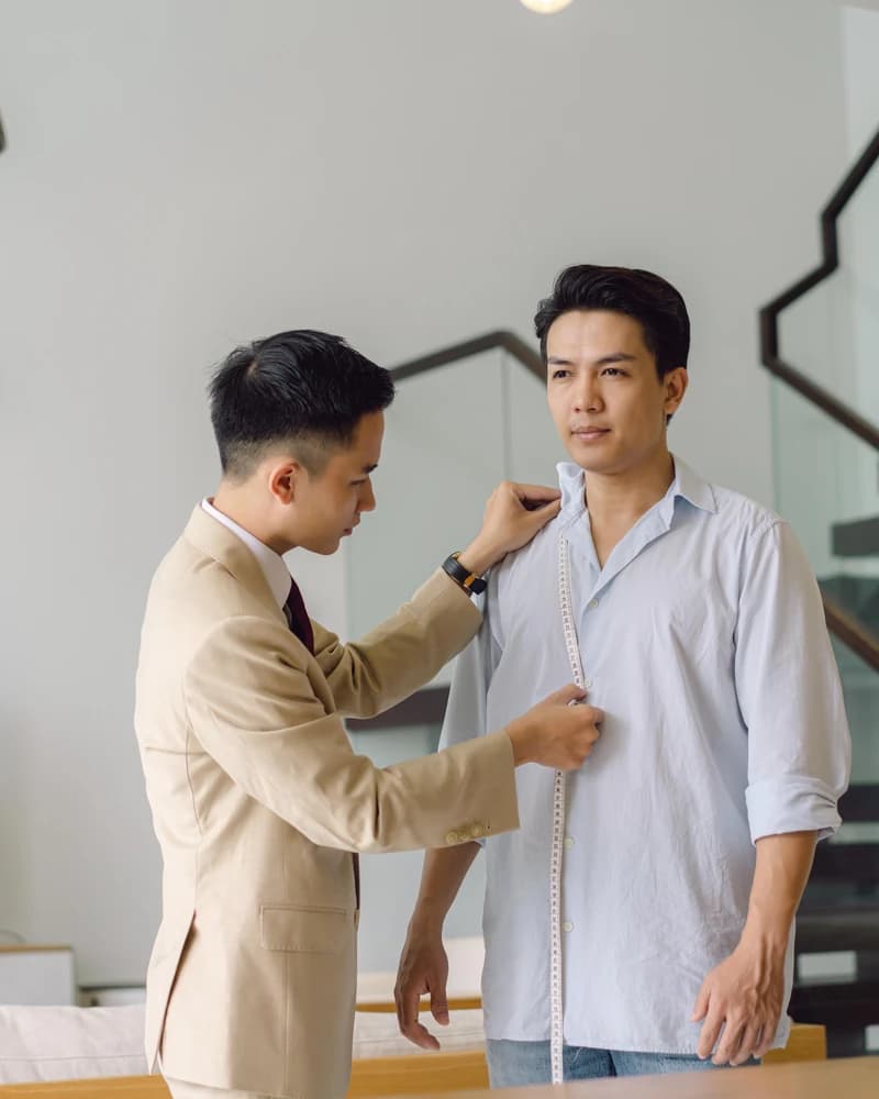 Tailor taking a client's measurements with a tape measure